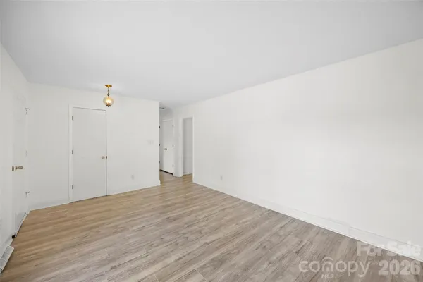 a view of a room with wooden floor and white walls