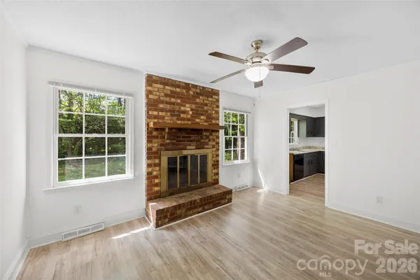 a living room with wooden floor and a ceiling fan