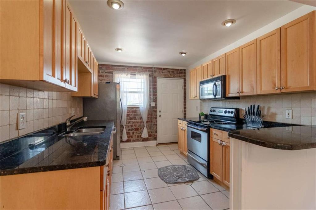 24 Daniel Street Southeast, Unit 8 Atlanta, GA 30312 - Photo 13 of 29 a kitchen with a sink a stove and cabinets