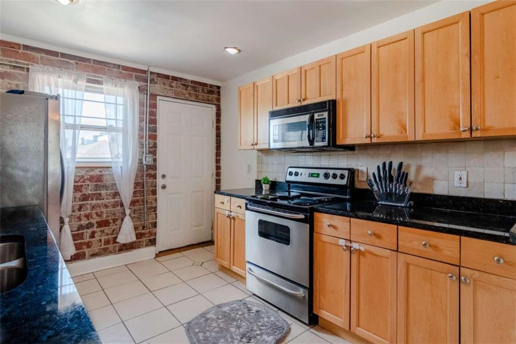 24 Daniel Street Southeast, Unit 8 Atlanta, GA 30312 - Photo 16 of 29 a kitchen with stainless steel appliances granite countertop a refrigerator stove top oven and sink