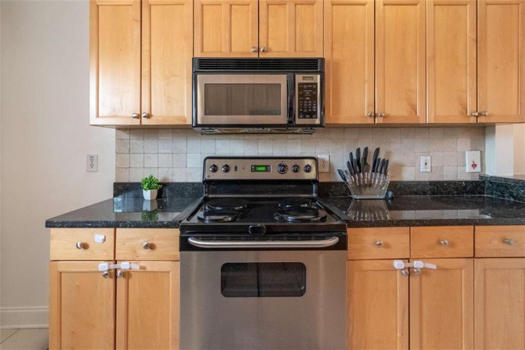 24 Daniel Street Southeast, Unit 8 Atlanta, GA 30312 - Photo 17 of 29 a kitchen with stainless steel appliances granite countertop a stove a microwave and cabinets