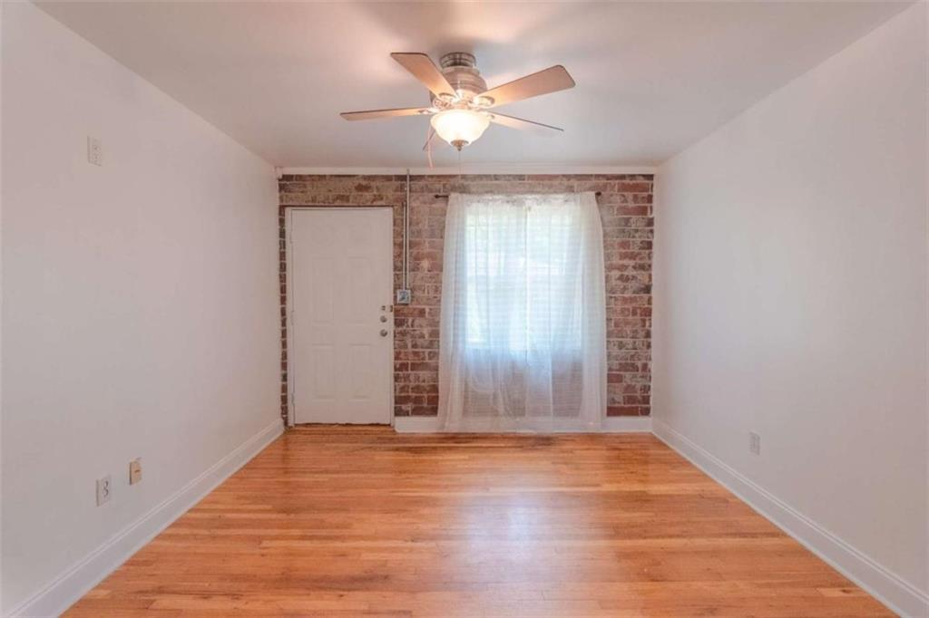 24 Daniel Street Southeast, Unit 8 Atlanta, GA 30312 - Photo 9 of 29 an empty room with wooden floor chandelier fan and windows