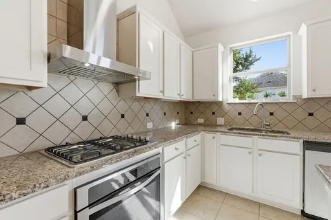 a kitchen with white cabinets and appliances