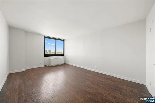 a view of an empty room and wooden floor