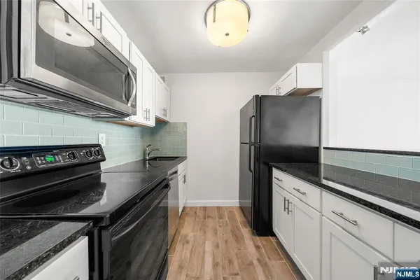 a kitchen with stainless steel appliances granite countertop a sink stove and microwave