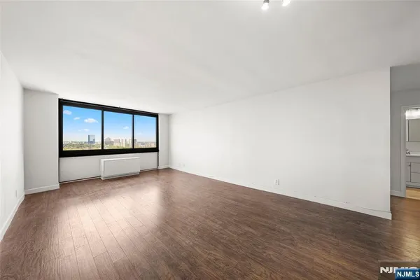 a view of empty room with wooden floor