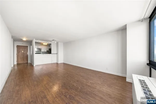 a view of a room with wooden floor and a bathroom