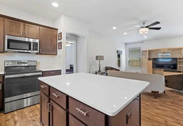 a kitchen with a refrigerator a sink and a stove top oven