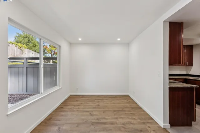 an empty room with wooden floor and window