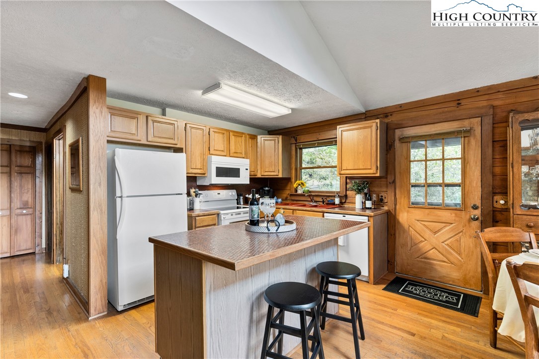 289 Grandview Drive Seven Devils, NC 28604 - Photo 7 of 43 a kitchen with stainless steel appliances granite countertop a refrigerator a stove a sink a dining table and chairs with wooden floor