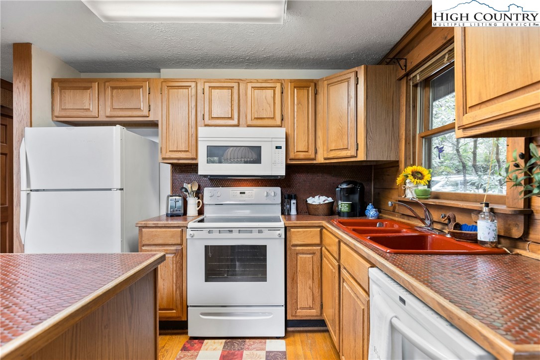 289 Grandview Drive Seven Devils, NC 28604 - Photo 8 of 43 a kitchen with stainless steel appliances granite countertop a stove a sink and a refrigerator