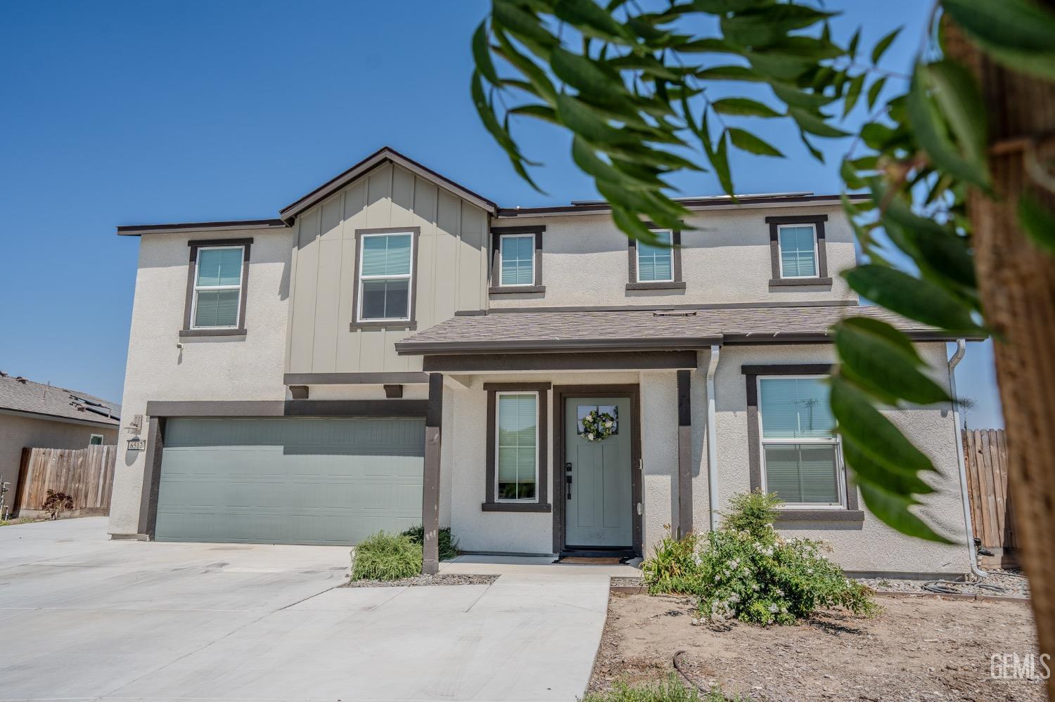 a front view of a house with a garden and garage