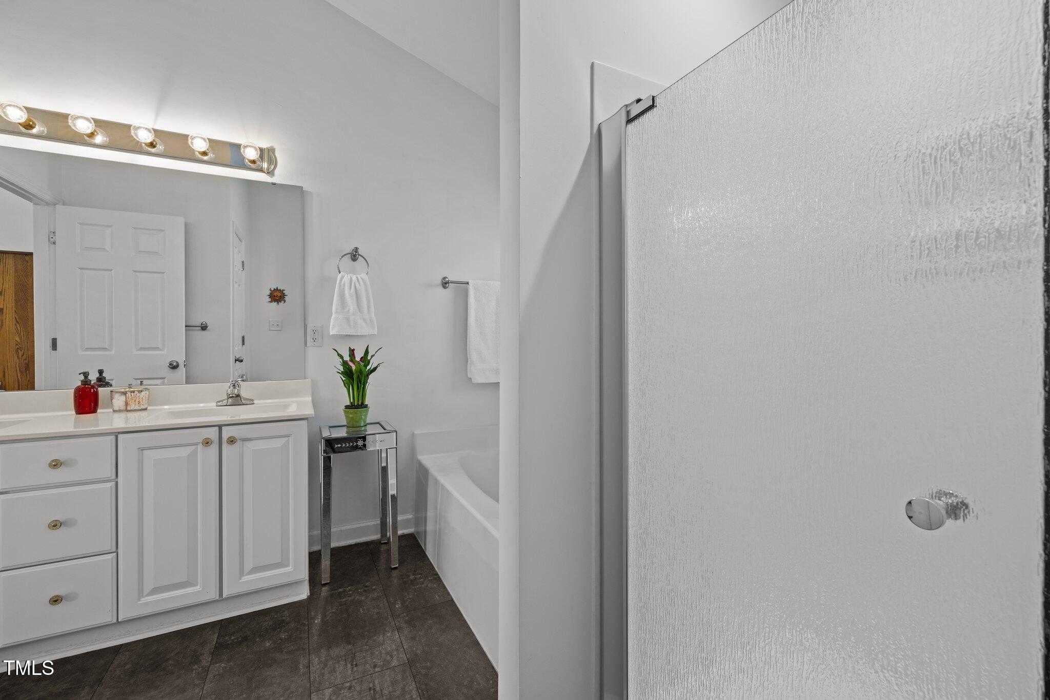 203 Stoney Drive Durham, NC 27703 - Photo 32 of 59 a bathroom with a double vanity sink and mirror
