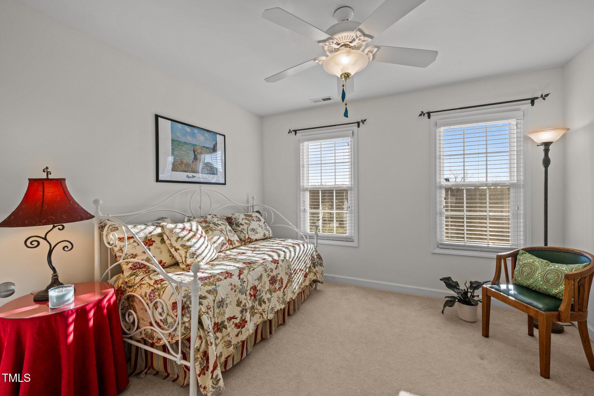 203 Stoney Drive Durham, NC 27703 - Photo 38 of 59 a spacious bedroom with a bed next to a window and a chandelier