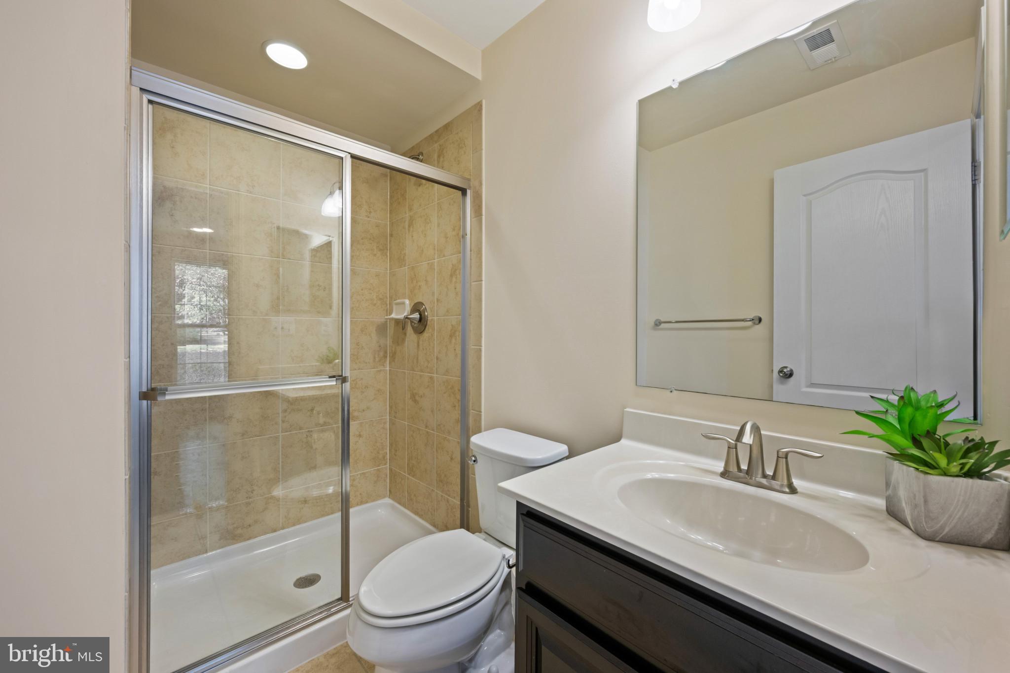 7062 Foxton Way Hanover, MD 21076 - Photo 9 of 41 a bathroom with a granite countertop sink a toilet a mirror and shower