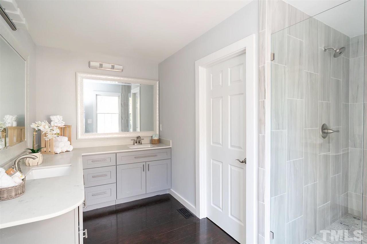 5501 Knollwood Road Raleigh, NC 27609 - Photo 15 of 25 a bathroom with a double vanity sink a mirror and a bathtub