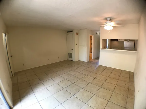 a view of a livingroom with an empty space and a ceiling fan