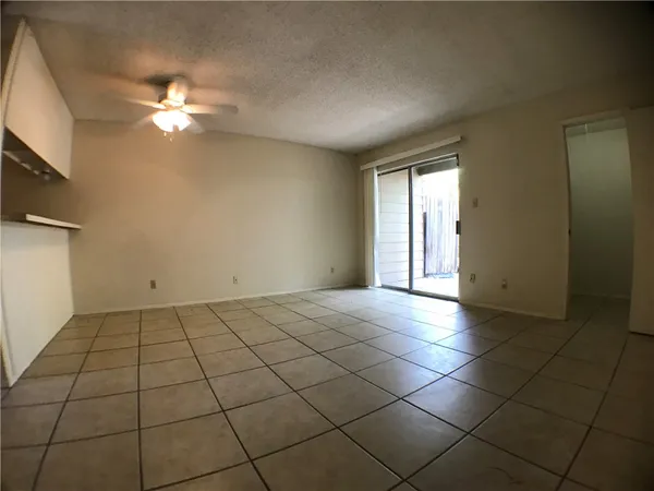 a view of an empty room and window chandelier fan