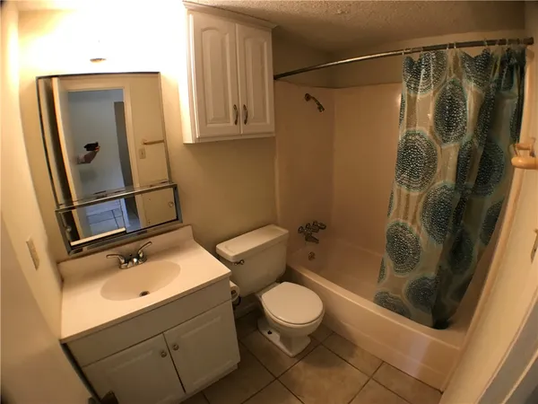 a bathroom with a shower a toilet and a sink