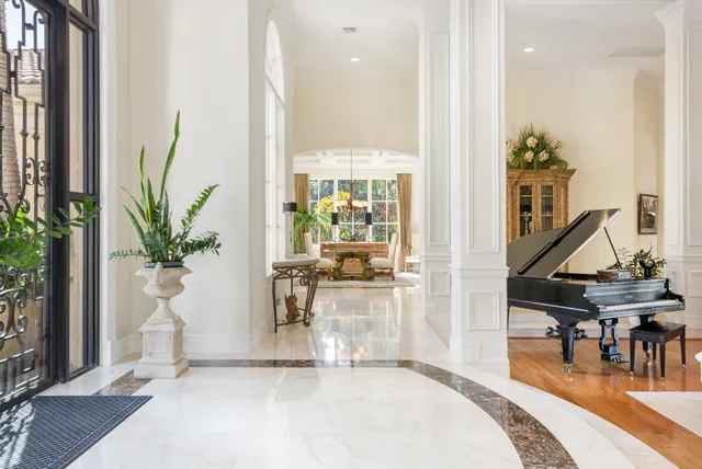 a living room with furniture a piano and a potted plant