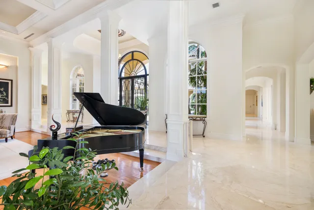 a large white kitchen with granite countertop a sink and cabinets