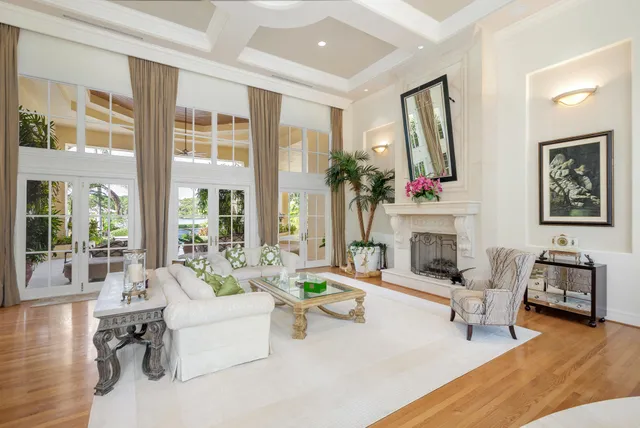 a living room with furniture a fireplace and a large mirror next to a window