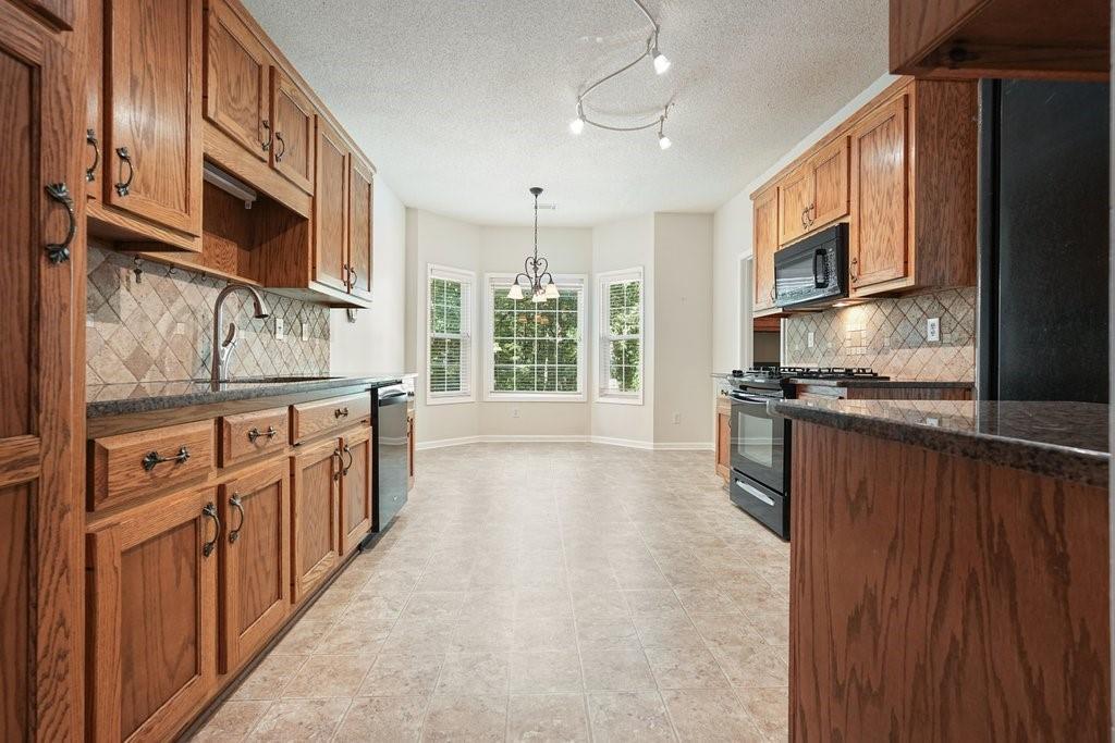 710 Bedford Trace Canton, GA 30114 - Photo 11 of 44 a kitchen with stainless steel appliances granite countertop a stove a sink and a microwave