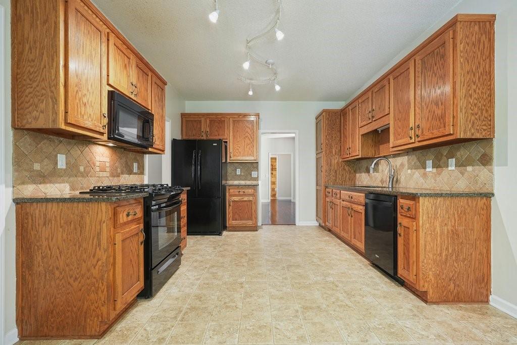 710 Bedford Trace Canton, GA 30114 - Photo 13 of 44 a kitchen with stainless steel appliances granite countertop wooden cabinets a refrigerator and a sink