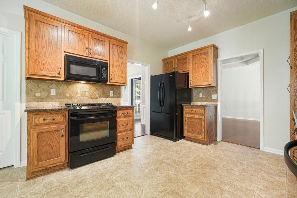 710 Bedford Trace Canton, GA 30114 - Photo 14 of 44 a kitchen with stainless steel appliances granite countertop a refrigerator microwave and sink