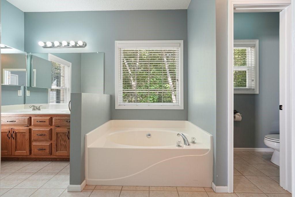 710 Bedford Trace Canton, GA 30114 - Photo 20 of 44 a white bath tub sitting in a bathroom with a tub sink and mirror