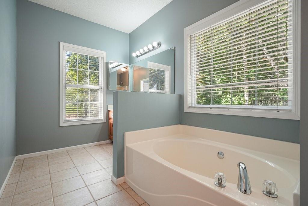 710 Bedford Trace Canton, GA 30114 - Photo 22 of 44 a bathroom with a bathtub and a window