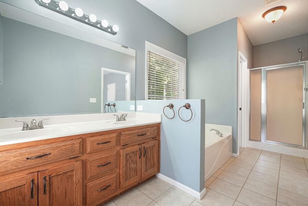710 Bedford Trace Canton, GA 30114 - Photo 23 of 44 a spacious en suite bathroom with a granite countertop sink and a mirror