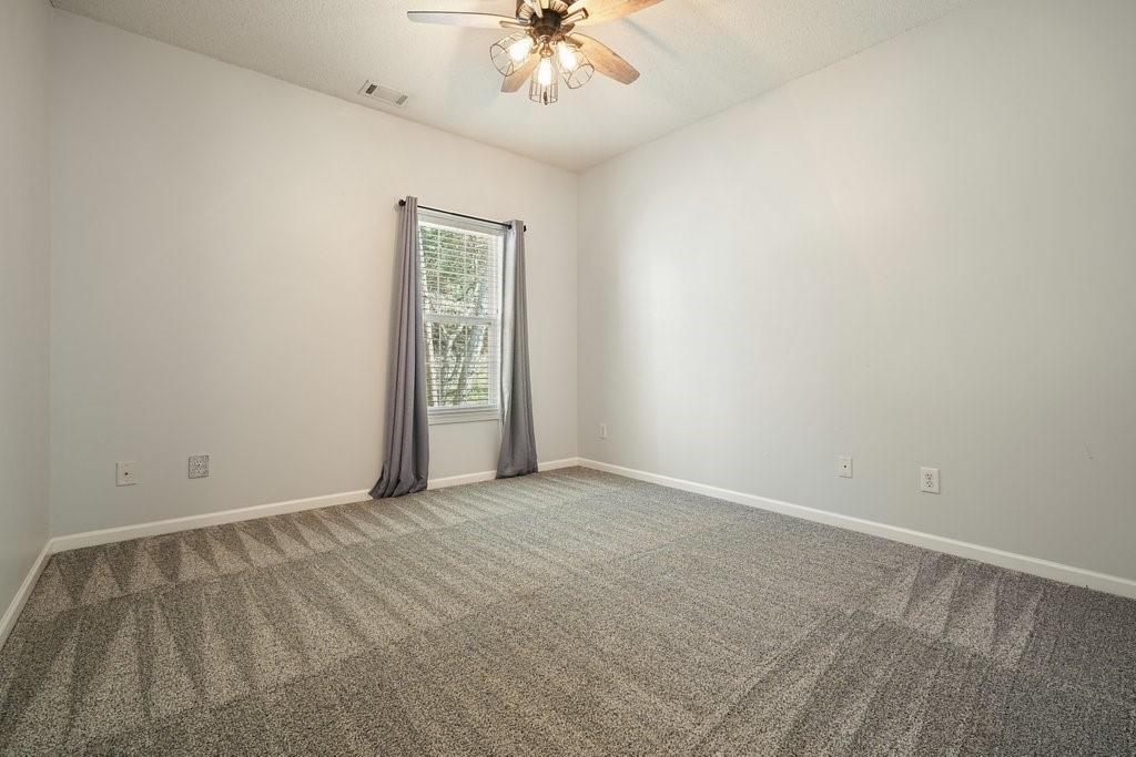 710 Bedford Trace Canton, GA 30114 - Photo 27 of 44 an empty room with a chandelier fan and windows