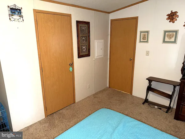 a view of a bedroom with wooden floor and a hallway