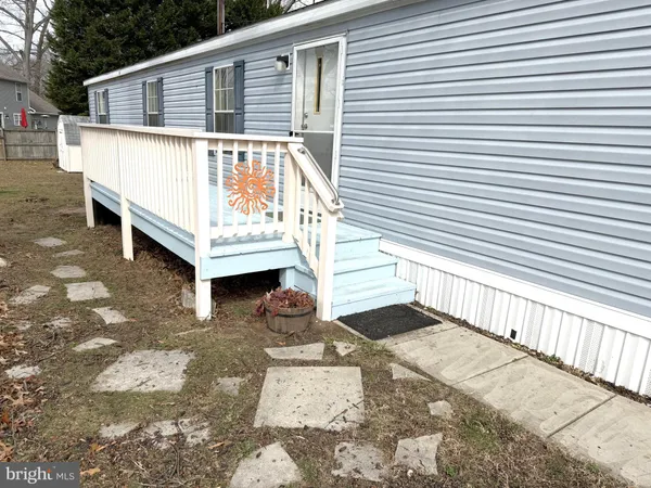 a view of a small house with wooden fence