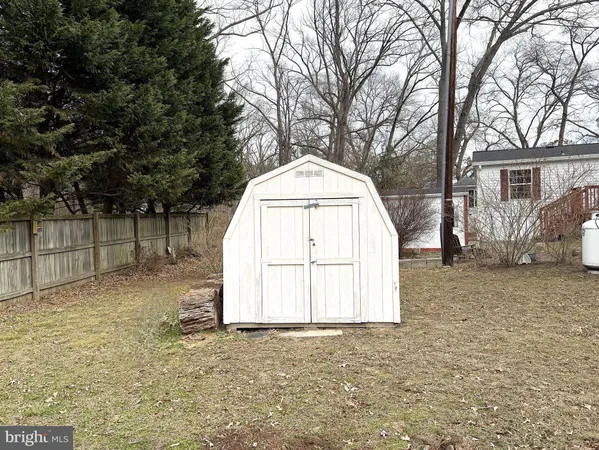 a view of backyard with large trees and wooden fence