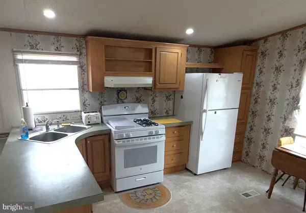a kitchen with a refrigerator a stove a sink a washer and cabinets