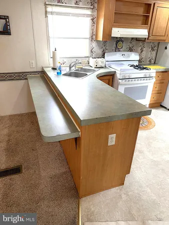 a view of kitchen with a sink a microwave and a stove