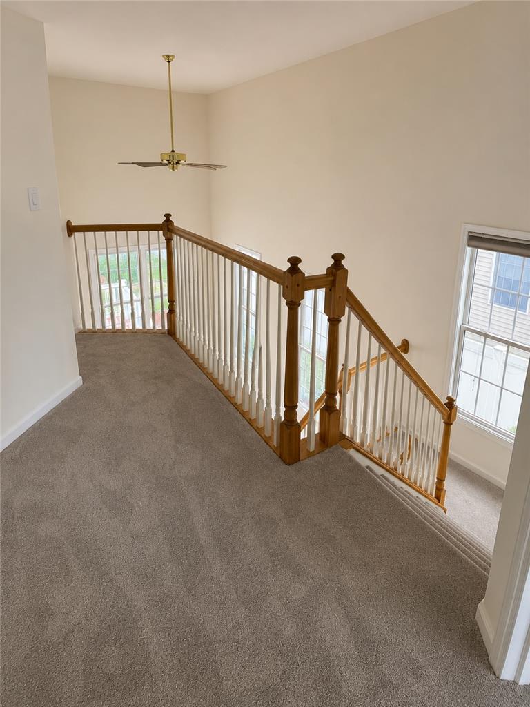 511 Howertown Road Northampton, PA 18067 - Photo 12 of 34 A well-lit stairwell features a classic wooden banister and soft carpeting.