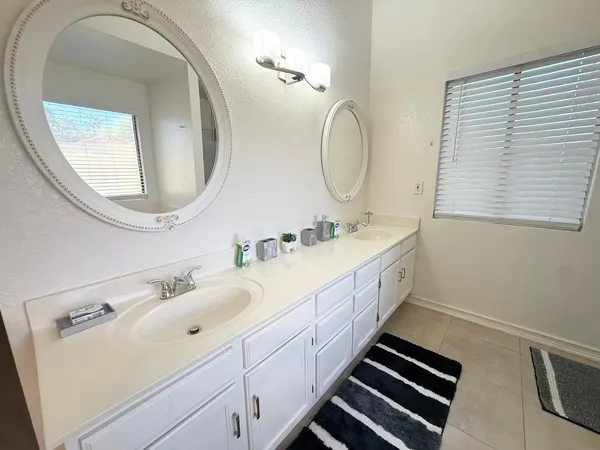 a spacious bathroom with a double vanity sink and a mirror