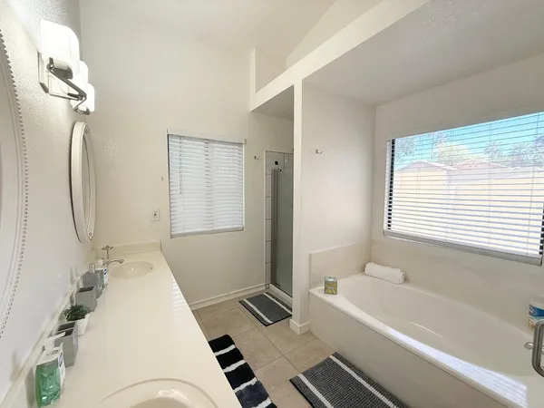 a large bed sitting in a bedroom next to a window