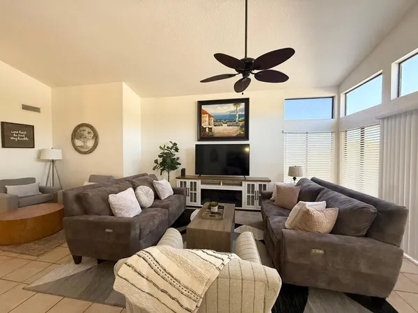 a living room with furniture a ceiling fan and a window