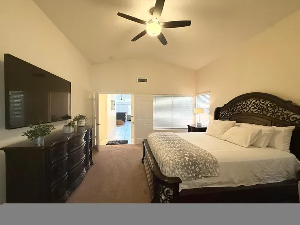 a bedroom with a bed and a flat screen tv