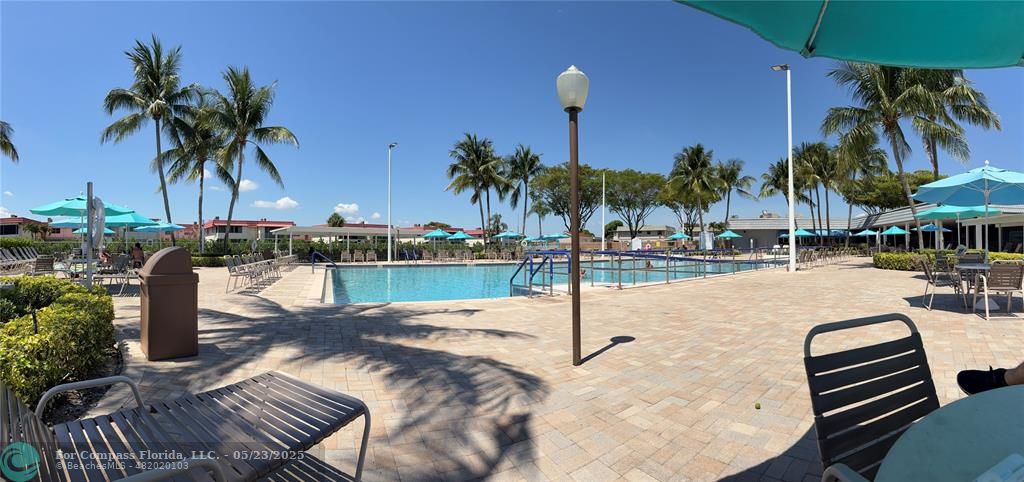 633 Brittany K, Unit 633 Delray Beach, FL 33446 - Photo 18 of 19 a view of a swimming pool with a table and chairs