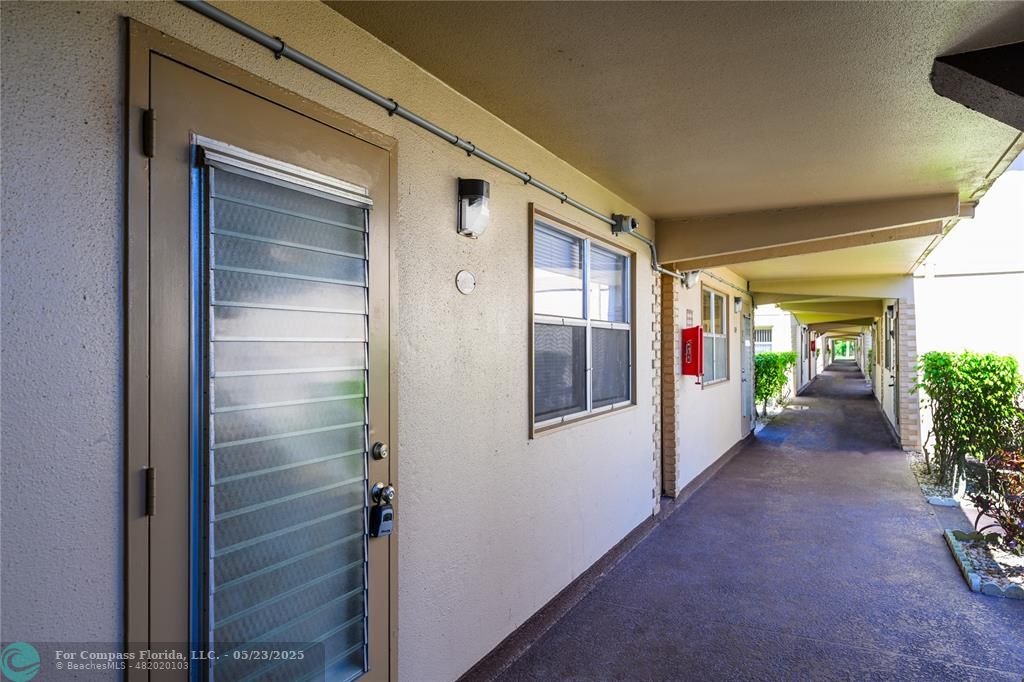 633 Brittany K, Unit 633 Delray Beach, FL 33446 - Photo 3 of 19 a view of a hallway with wooden walls and windows