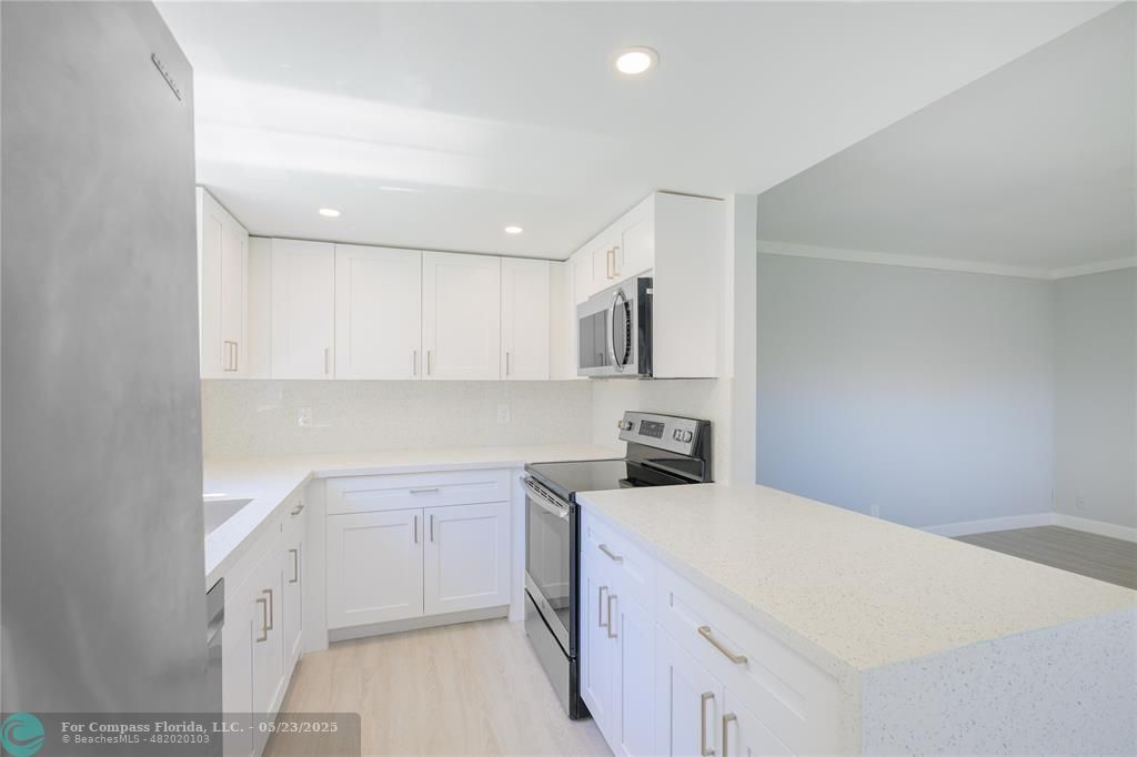 633 Brittany K, Unit 633 Delray Beach, FL 33446 - Photo 6 of 19 a kitchen with cabinets and white appliances