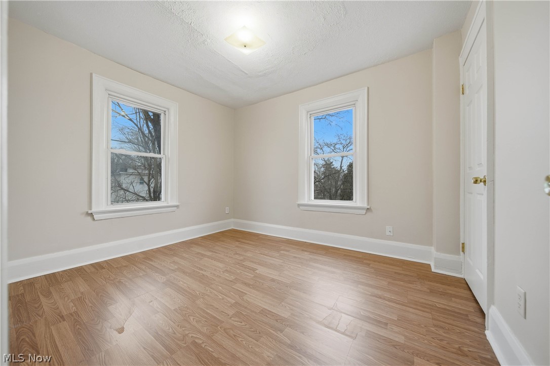 225 Cranz Place Akron, OH 44310 - Photo 23 of 34 Empty room with light wood-style flooring, healthy amount of natural light, and a textured ceiling