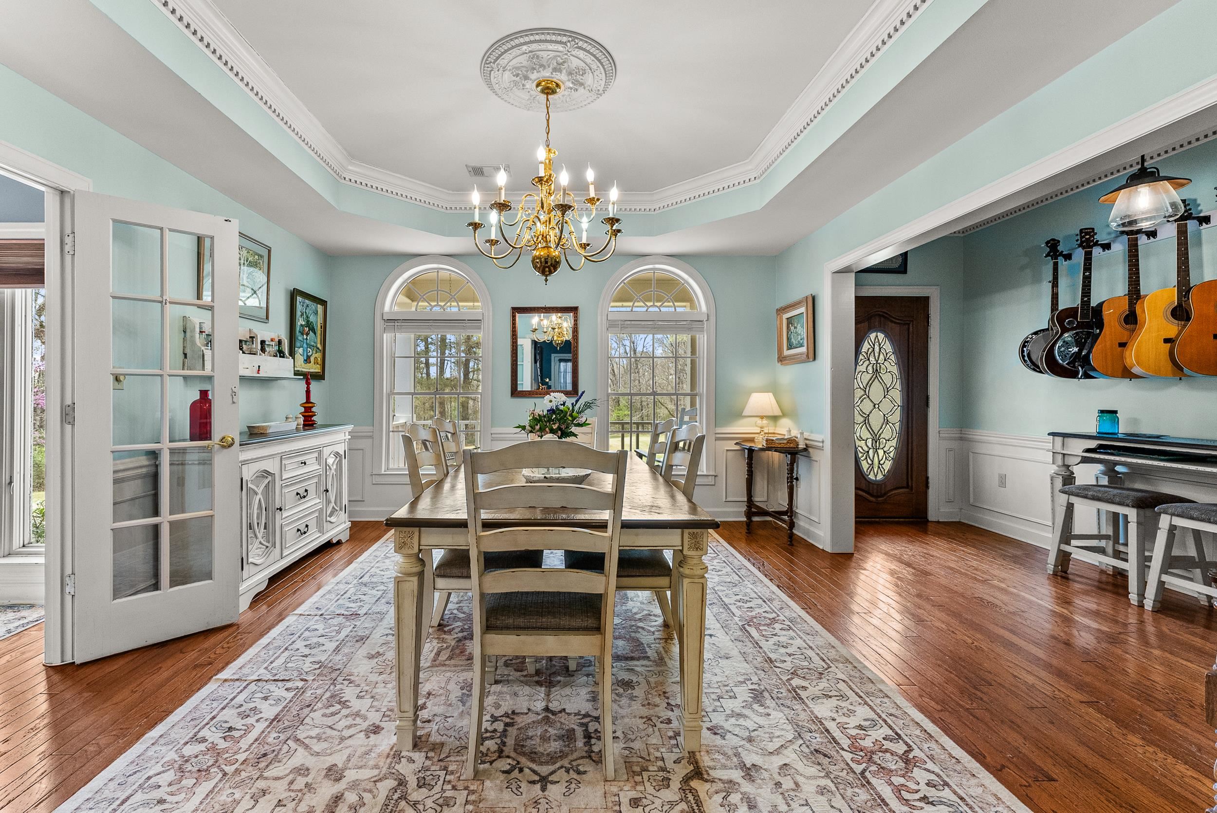 1459 C Vassar Road Pope, MS 38658 - Photo 15 of 40 Dining area featuring a tray ceiling, crown molding, an inviting chandelier, wood-type flooring, and a wainscoted wall