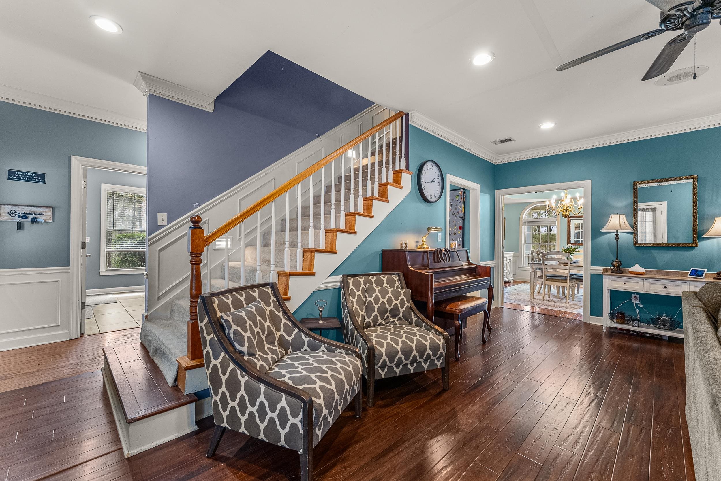 1459 C Vassar Road Pope, MS 38658 - Photo 23 of 40 Living area with a wainscoted wall, stairs, ceiling fan with notable chandelier, and wood-type flooring