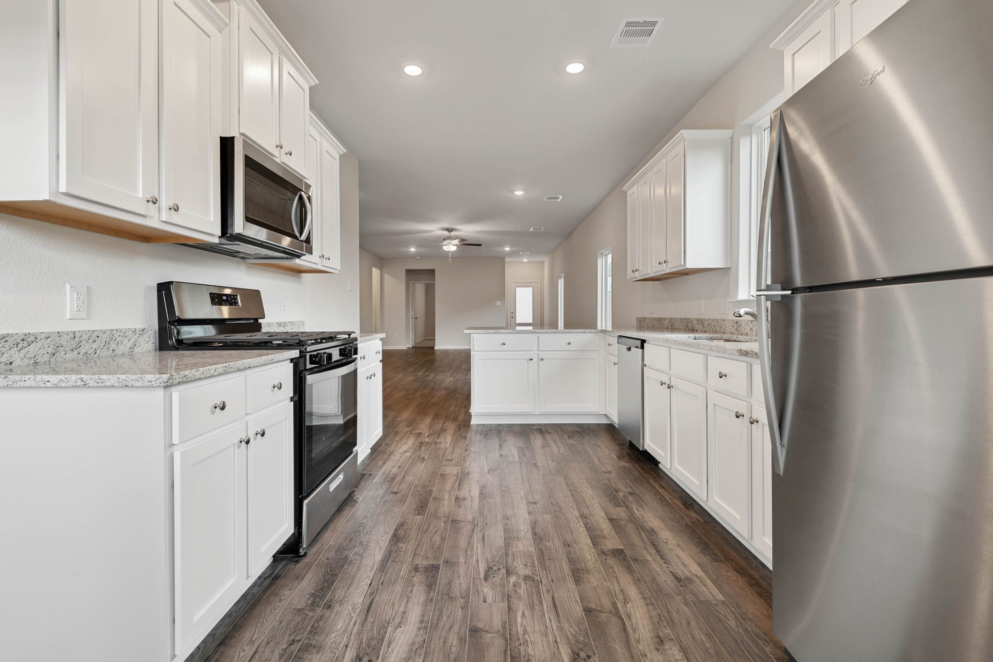 15806 Berry Hl Drive Conroe, TX 77303 - Photo 6 of 25 a large kitchen with stainless steel appliances granite countertop a stove a sink and a refrigerator
